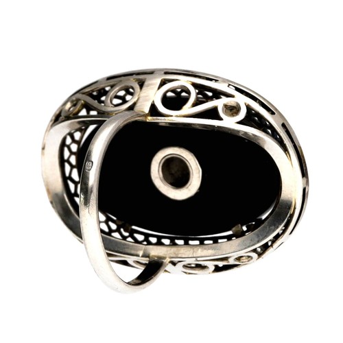 113 - Fancy large oval white metal diamond and black onyx cocktail ring, with a round brilliant-cut diamon... 