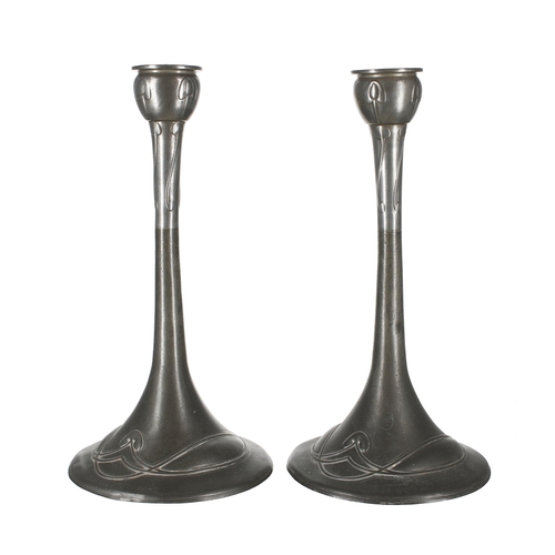 697 - Pair of Art Deco Tudric pewter candlesticks, decorated with stylized interlaced borders and flower h... 