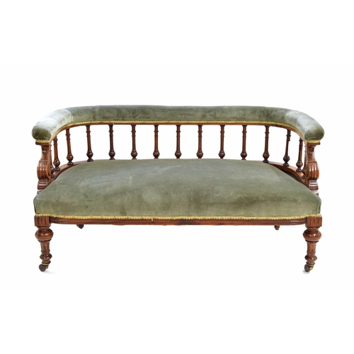 975 - Victorian spindle-back salon settee, the curved back and seat in green stuff-over upholstery, raised... 