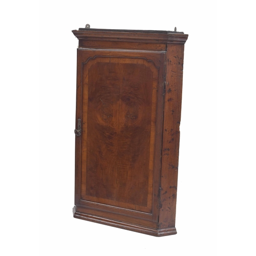 973 - Georgian mahogany/walnut hanging corner cupboard, the moulded cornice over a cross-banded door with ... 