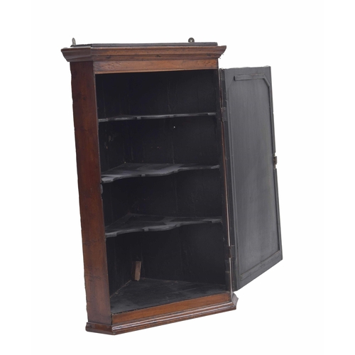 973 - Georgian mahogany/walnut hanging corner cupboard, the moulded cornice over a cross-banded door with ... 