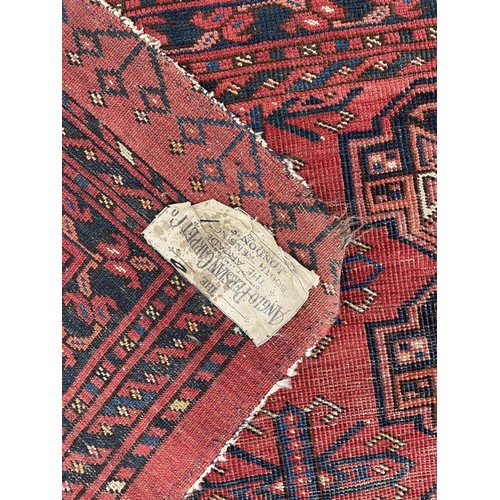 916 - Small red ground Persian pattern rug, labelled The Anglo Persian Carpet Co. Direct Importers.., 34