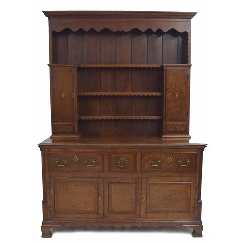 982 - Good George III oak and mahogany crossbanded dresser, the raised panelled back with a shaped frieze ... 