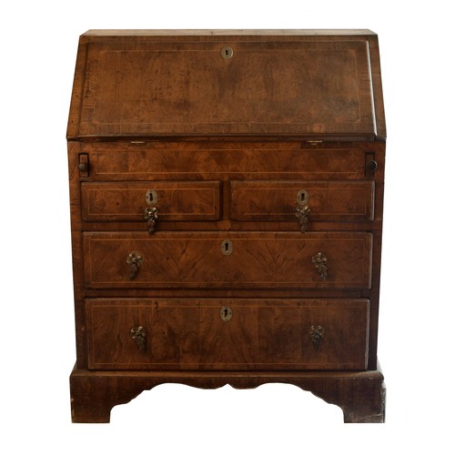 1765 - George II walnut and feather banded bureau, the fall front enclosing a fitted interior with a well, ... 