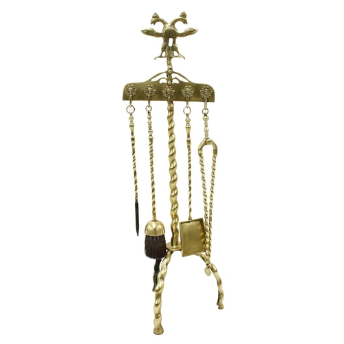 1187 - 19th century brass fireside companion set, the stand surmounted with an eagle crest over a twisted s... 