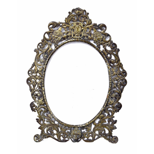 1164 - Rococo style gilt metal oval frame, decorated with foliate scrolls over a single mask to the base, 2... 