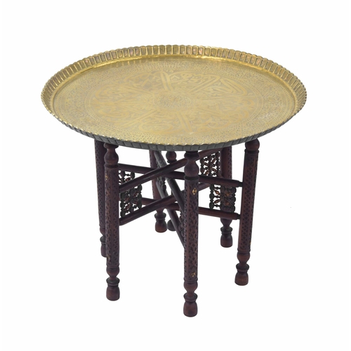 1603 - Decorative Indian brass tray-top occasional table on a carved folding stand, 28.5” diameter... 