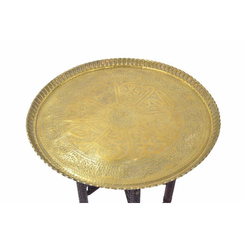 1603 - Decorative Indian brass tray-top occasional table on a carved folding stand, 28.5” diameter... 