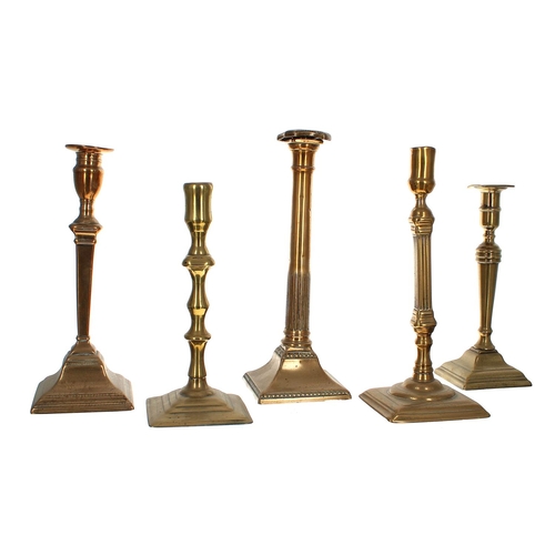 1099 - Five 18th century single brass candlesticks with square bases, 9.5