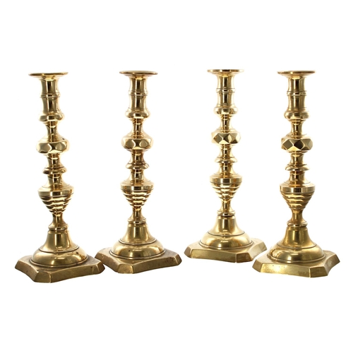 1121 - Set of four Victorian brass candlesticks, with turned stems and square canted bases, 12” approx (4)... 