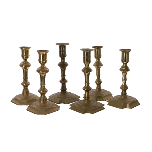 1053 - Three pairs of 18th century brass candlesticks, the tallest pair 7.5” high (6)