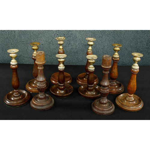 1010 - Five assorted pairs of turned oak and treen candlesticks, the tallest pair 10