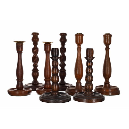 1011 - Four pairs of turned oak candlesticks including a pair of barley twist examples, the tallest pair 12... 