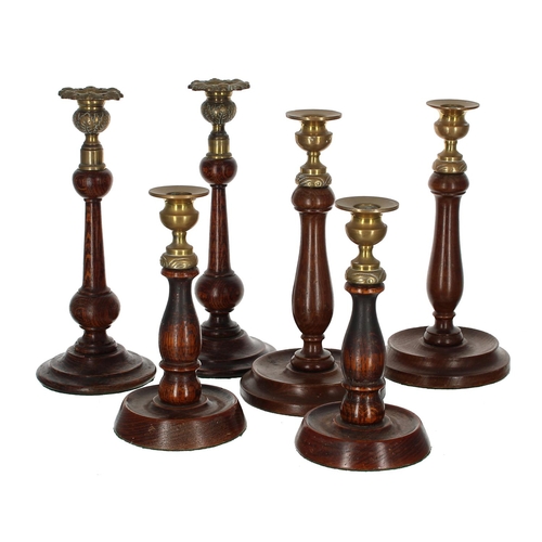 1062 - Three pairs of antique oak candlesticks, each with decorative brass sconces, tallest pair 10