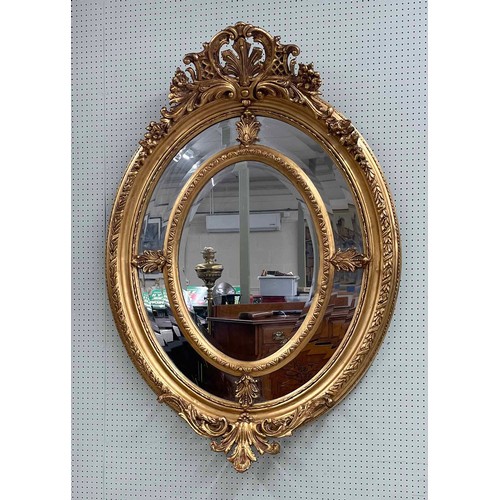 817 - Large and impressive oval French Rococo style wall mirror, surmounted by a scrolling foliate pedimen... 