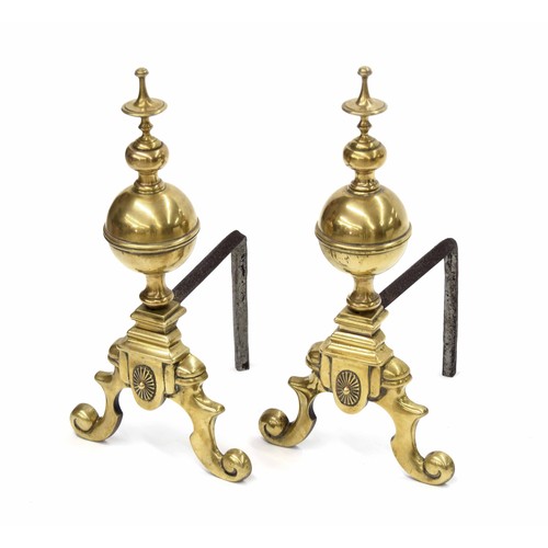 1032 - Pair of large Classical style brass and iron andirons, with turned finials and supports upon scroll ... 