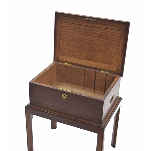 1084 - Oak and elm box on stand, with recessed brass side carry-handles and hinged top with an open interio... 