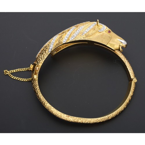 136 - Fine high grade yellow gold diamond set horse design hinged bangle, with gem set eyes, safety chain,... 