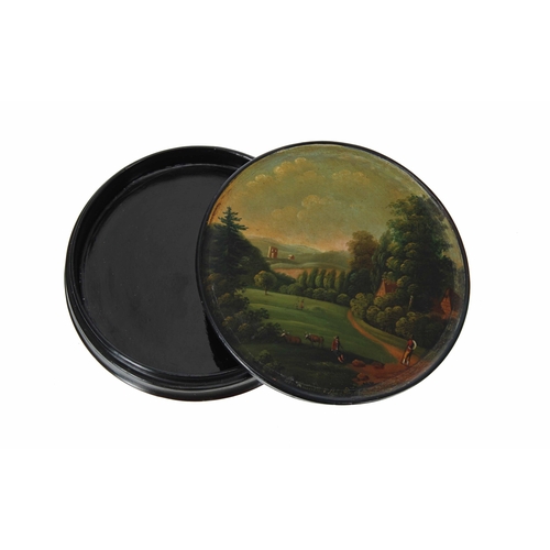 538 - 19th century lacquered mache circular snuff box, the cover with painted landscape with ruins, trees ... 