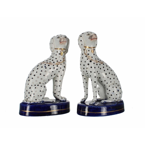 615 - Pair of Staffordshire pottery Dalmatian figures, with gilt highlight collars on enamel blue bases wi... 