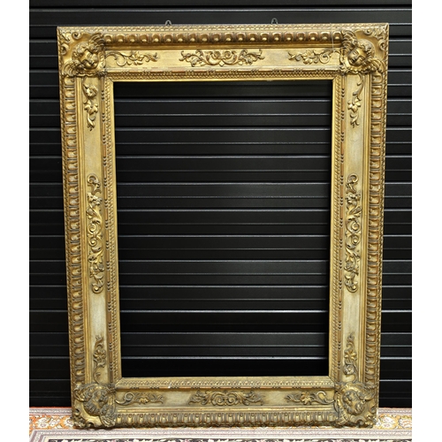 734 - Large ornate giltwood and gesso frame, the corners with winged putti, 44