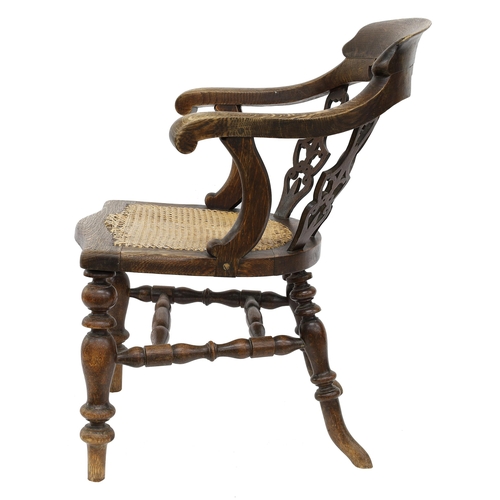 801 - Oak captain's armchair, the curved back with three pierced splats over a bergere seat upon turned le... 