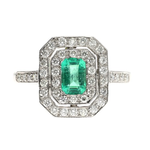 72 - Attractive platinum emerald and diamond cluster ring, the emerald 0.6ct approx, in a rectangular set... 