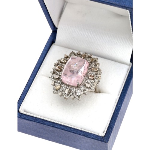 114 - Large silver dress ring set with a central cushion cabochon morganite, with surrounding baguette and... 