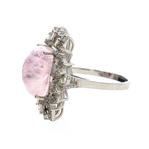 114 - Large silver dress ring set with a central cushion cabochon morganite, with surrounding baguette and... 