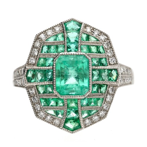 124 - Ornate platinum emerald and diamond dress ring in the Art Deco style, the central step-cut emerald 0... 