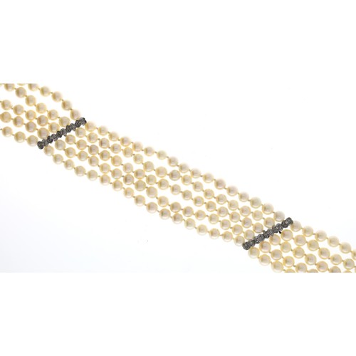 34 - Good cultured pearl five strand necklace, with white gold spacer mounts set with diamonds, each row ... 