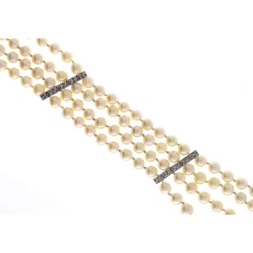 37 - Cultured pearl four strand bracelet, with white gold spacer mounts, each row consisting of 27 unifor... 