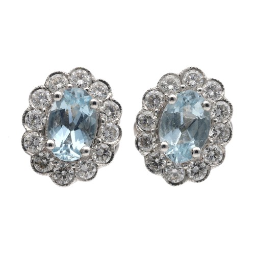 100 - Pair of modern 18ct white gold oval aquamarine and diamond cluster earrings, the aquamarines each 0.... 