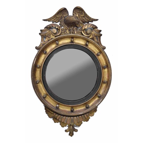 825 - 19th century convex giltwood and gesso convex wall mirror, surmounted by an eagle over a circular fr... 