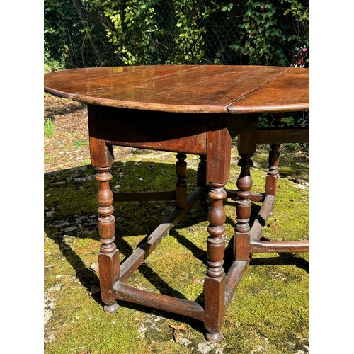 1710 - 18th century elm oval gateleg dropleaf dining table, with a single frieze end drawer and upon balust... 