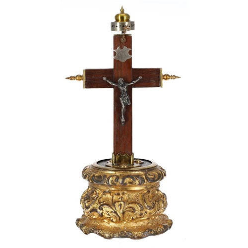 1305 - Small crucifix clock, the wooden cross surmounted by a horizontal silvered twelve hour chapter ring ... 