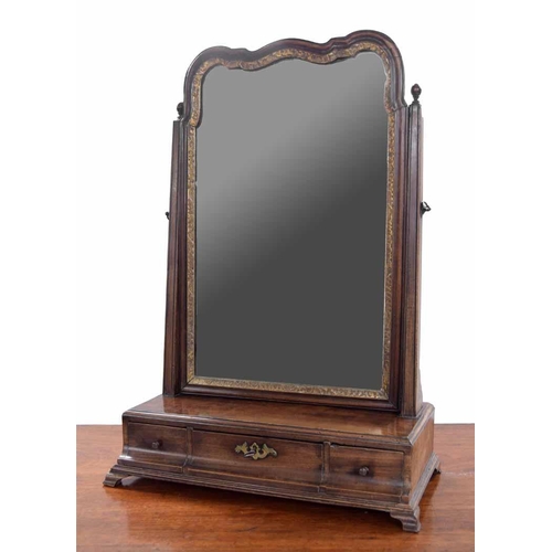 945 - Georgian mahogany dressing/toilet mirror, with shaped glass in a gilt border, on finial supports ove... 