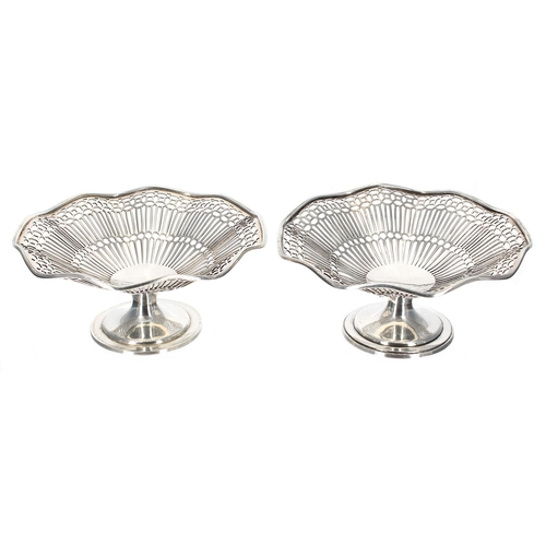 562 - Two pairs of similar silver sweetmeat baskets, with wavy edges raised on pedestal supports, makers G... 