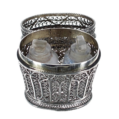 1182 - Attractive filigree white metal oval scent bottle holder, the foliate hinged top enclosing a pair of... 