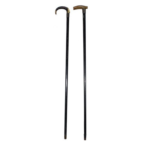 1280 - Two similar Victorian horn handled and ebonised gentleman's walking canes, each with a foliate engra... 