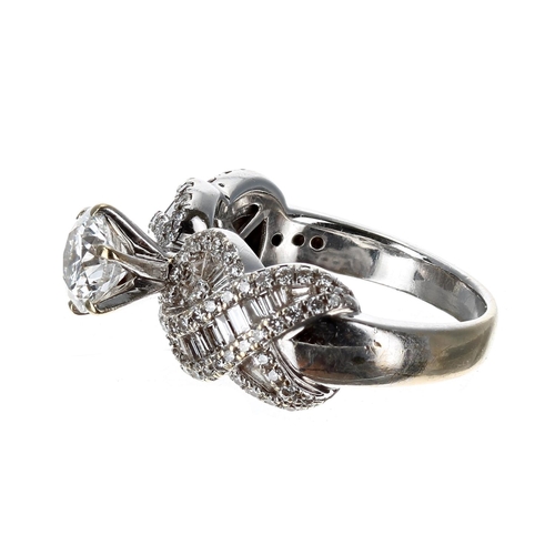 74 - Impressive 18ct white gold diamond set ring, with a central raised diamond on a crossover design dia... 