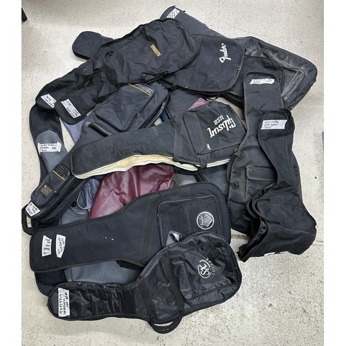 1094 - Approximately fourteen guitar gig and soft bags to include one Gibson USA, one Fender, one Warwick e... 