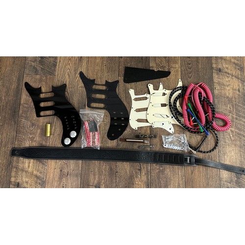 1493 - Selection of guitar accessories to include pickguards, bridges, a guitar slide, two guitar straps, t... 