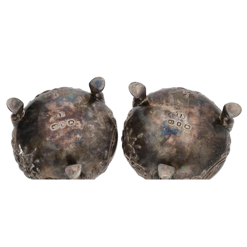 409 - Pair of Victorian silver circular salts, ornate floral embossed decoration on pad feet, blue glass l... 