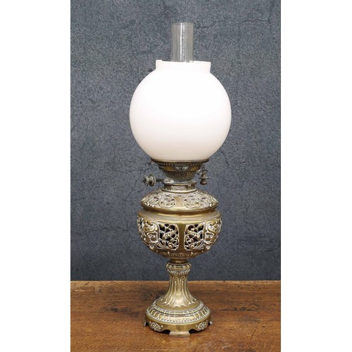 627 - Victorian brass oil lamp, with ornate leaf and scroll ornament, opaque glass shade (damaged) and cle... 