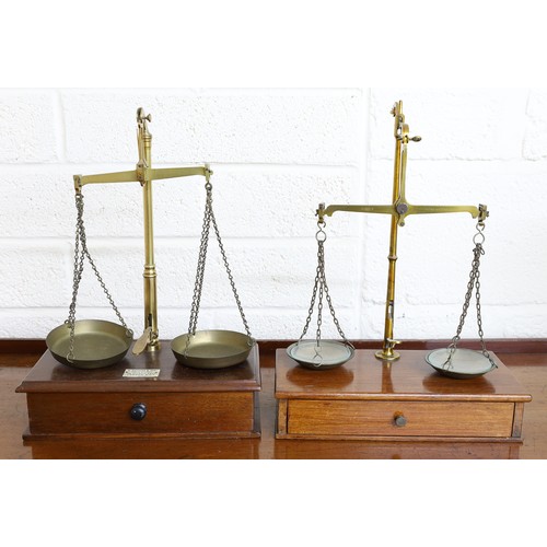 100 - Set of brass beam scales, brass central column and pans, on mahogany base, brass weights to drawer, ... 