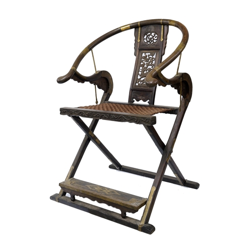 Chinese brass mounted horseshoe back folding armchair, Jiaoyi, late Qing Dynasty and possibly Huanghuali, the broad splat with carved and pierced central panel depicting a Qilin, ropework seat and inlaid foot rest, 44" high