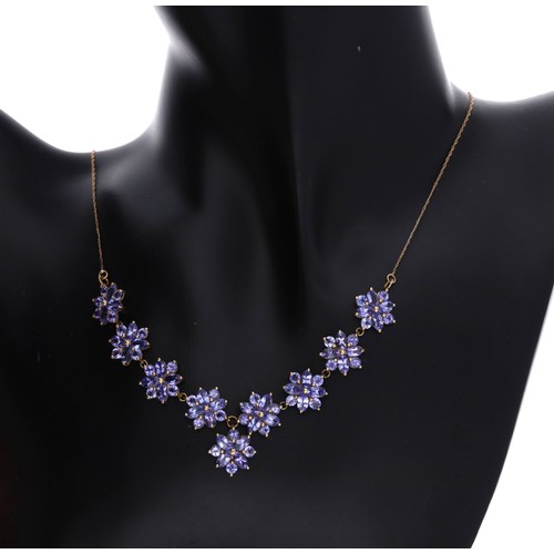28 - Attractive tanzanite floral cluster 9ct necklace, consisting of nine floral clusters set with marqui... 