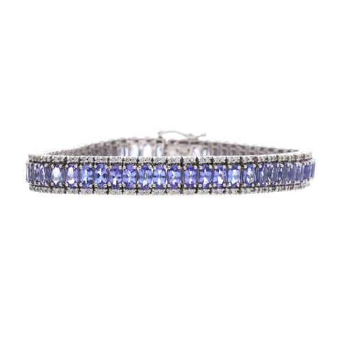 29 - Iliana 18ct white gold tanzanite and diamond bracelet, with a centre band of oval tanzanite within r... 