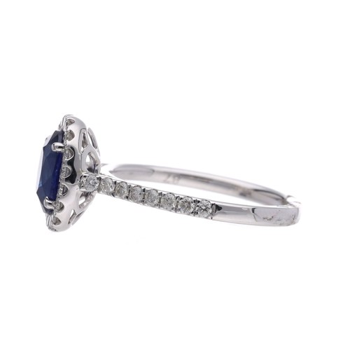 25 - Modern white gold oval sapphire and diamond cluster ring with diamond set shoulders, the oval sapphi... 